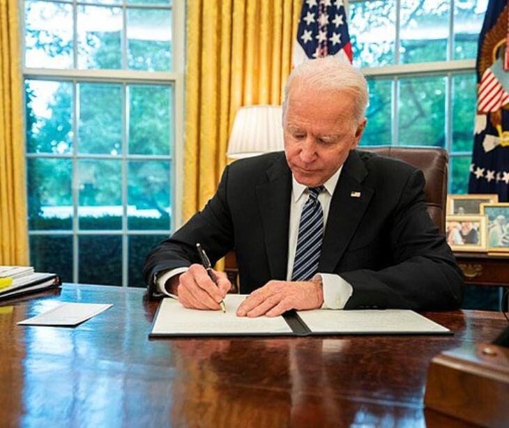 president biden signing papers