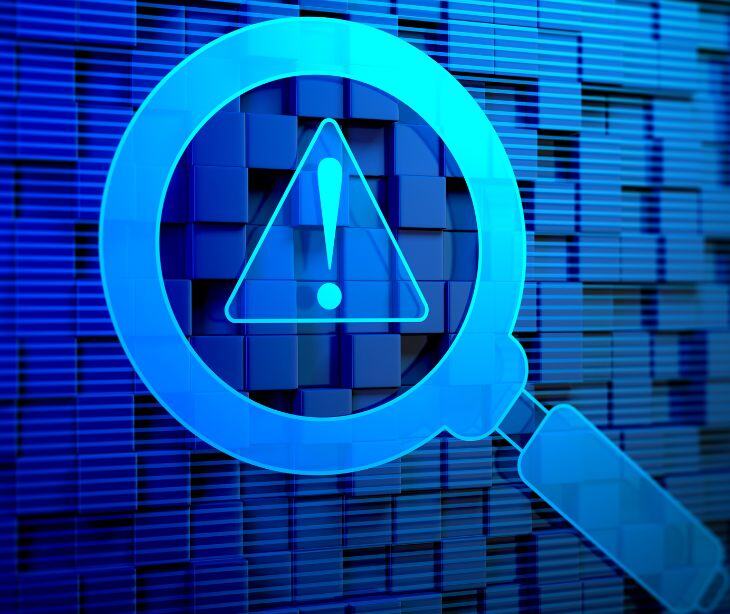 digital caution symbol and magnifying glass