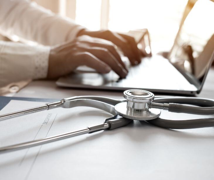 doctor at computer with stethoscope