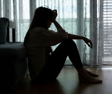 woman in the shadows of bedroom for post HIPAA compliant communication for treating perinatal depression