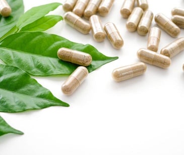 brown supplement capsules with green leaves