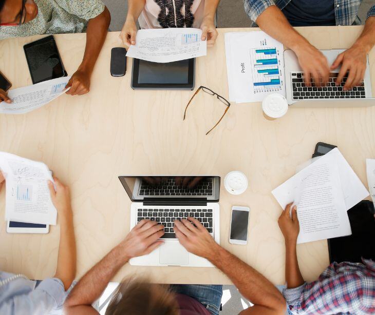 laptops and phones being used at a group desk