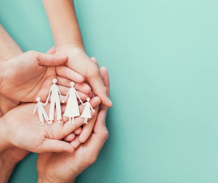 hands with cutout of family