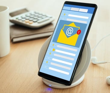 smartphone on desk with email notification on screen