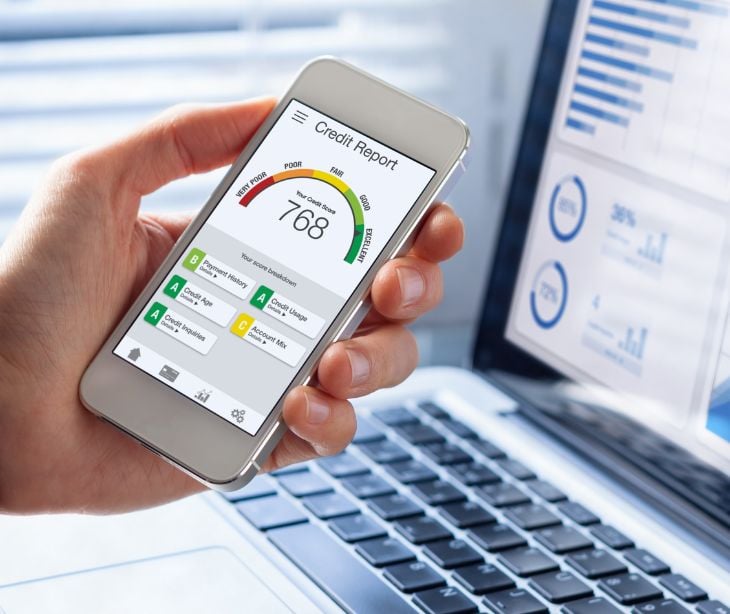 credit report chart on a cellphone in front of a laptop screen