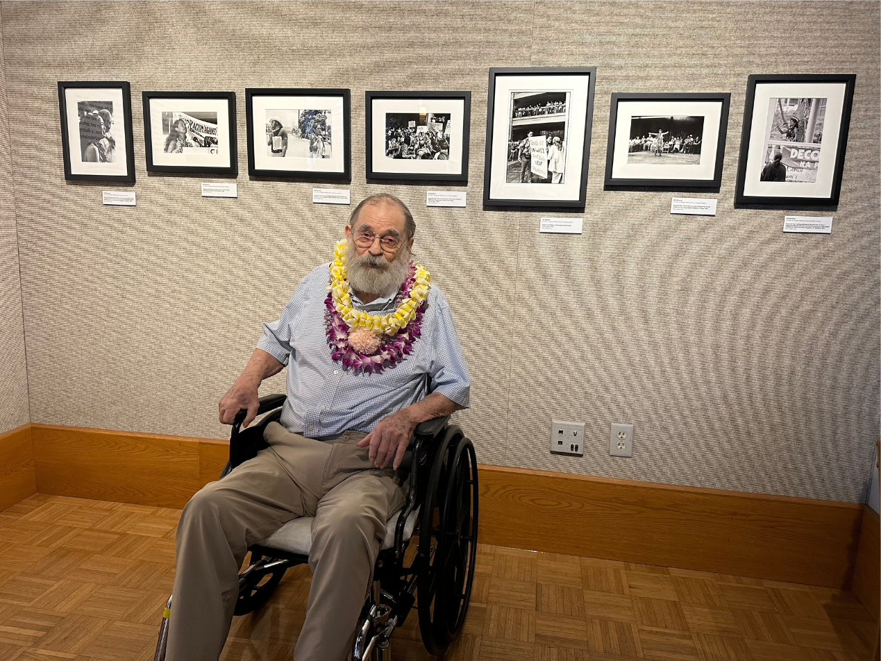 Ed Greevy with his seven prints of Haunani-Kay Trask behind him | Opening night: OG photogs at Windward Community College