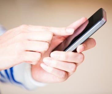 Image of individual texting for blog about HIPAA guidelines for texting PHI between doctors