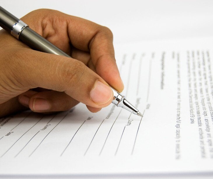 Image of someone signing a form for an article about Documenting HIPAA forms