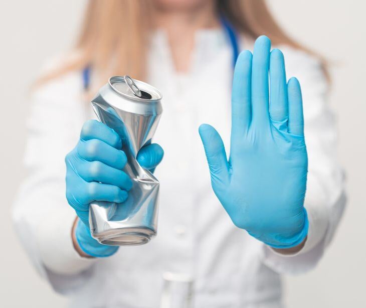 medical gloved hand crushing beer can