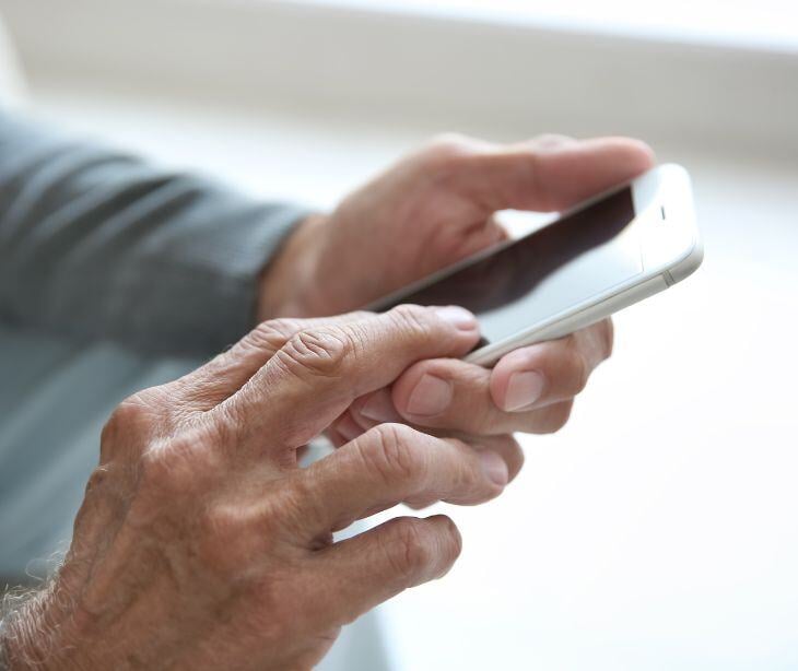 elder hands holding smartphone