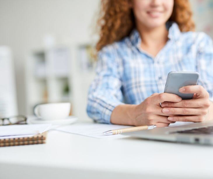 woman on smartphone for post What is HIPAA compliant texting and how to enforce it