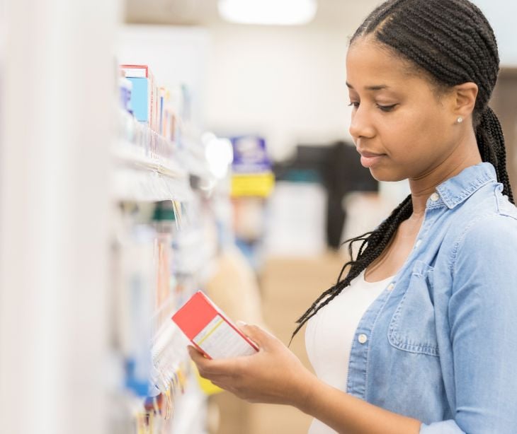 woman looking at medication at a pharmacy